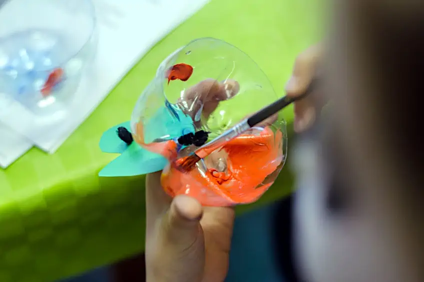 Child Painting Plastic Bottle with Acrylic